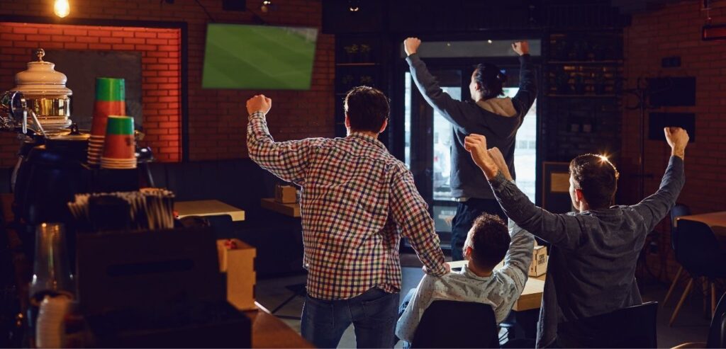 People enjoying a football match in a sports bar.